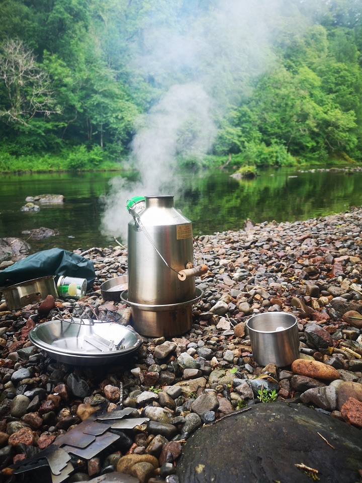 Kelly Kettle in gebruik langs een rivier
